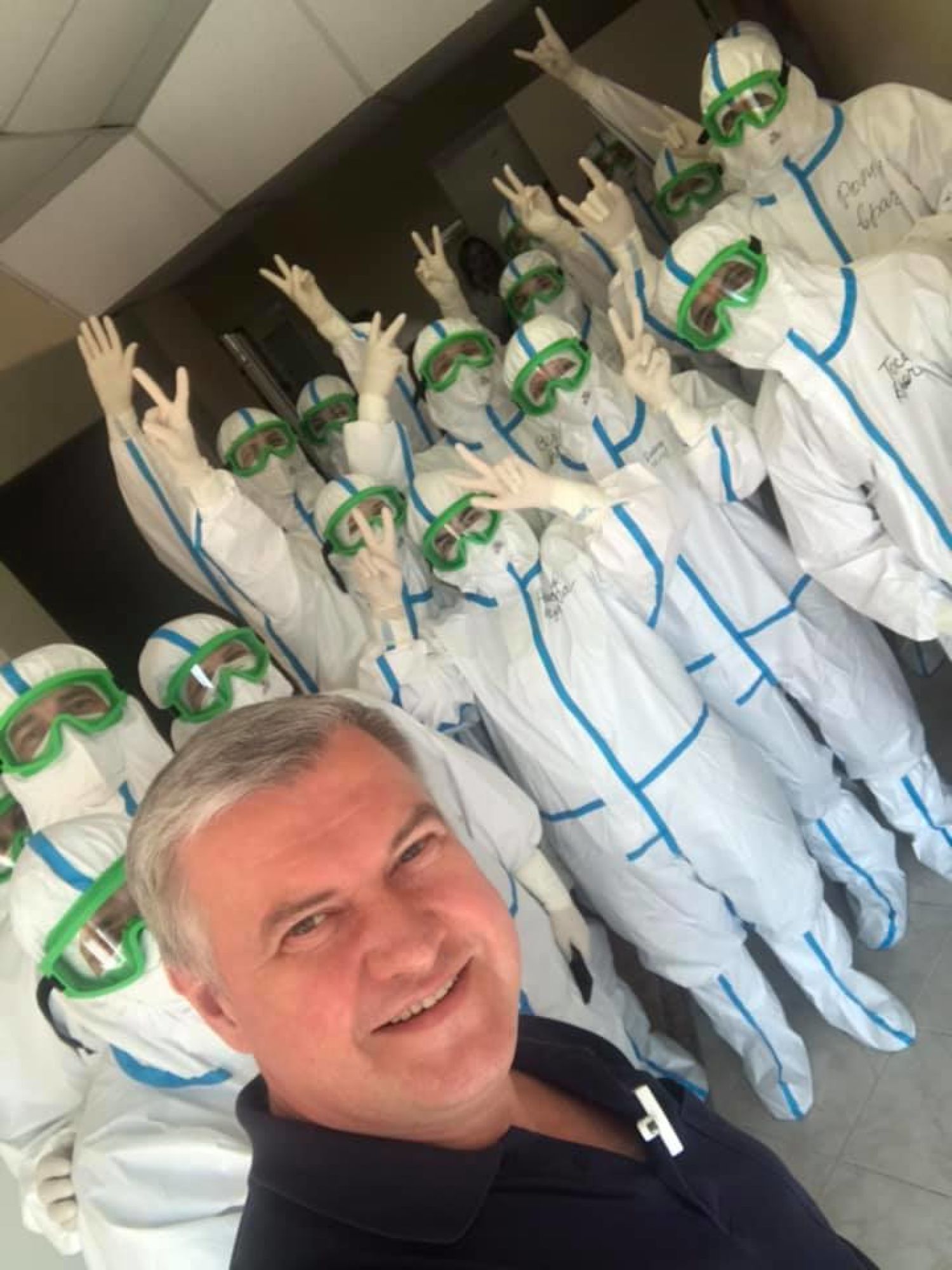 Виталий Гусаров с коллективом врачей в комбинезонах